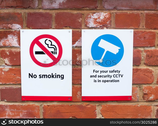two signs at train station cctv no smoking; essex; england; uk
