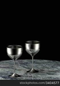 Two silver goblets on marble table