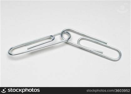 Two silver paper clips on white background