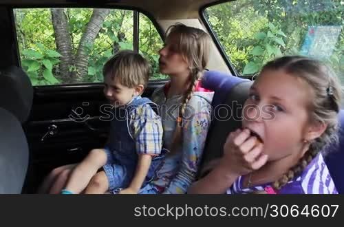 two sisters are happy to sit in back seat car, eldest girl is playing with little brother on her knees, then machine goes away