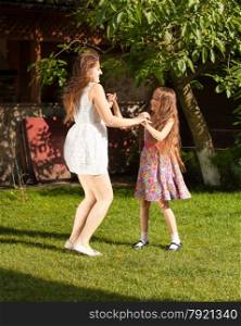 Two sisters having party and dancing on grass at yard