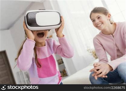 two sisters home playing with virtual reality headset
