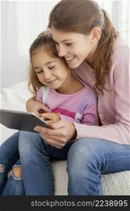 two sisters using tablet together home