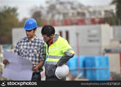 Two site workers sticking to the plans