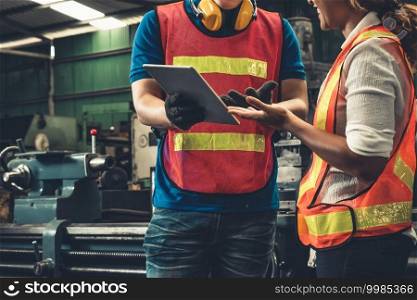 Two skillful factory engineer or worker discussing project on tablet computer . Industrial people and manufacturing labor concept .. Two skillful factory engineer or worker discussing project on tablet computer