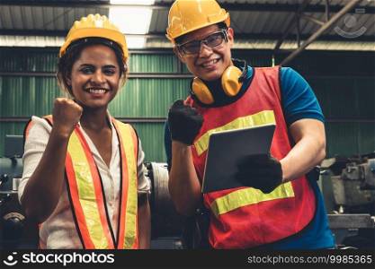 Two skillful factory engineer or worker happy portrait looking at camera . Industrial people and manufacturing labor concept .. Two skillful factory engineer or worker happy portrait looking at camera