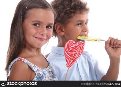 two skittish kids with lollypops