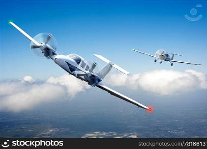 Two small aircraft in pursuit, racing through the clouds