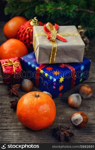 Two small boxes with gifts on the background of tangerine,spruce branch,hazelnuts