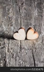 Two small hearts. Two small hearts on old wood background