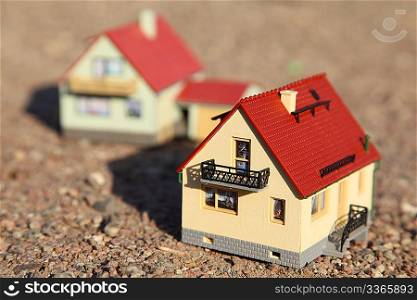 two small models of houses. front model of house in focus.