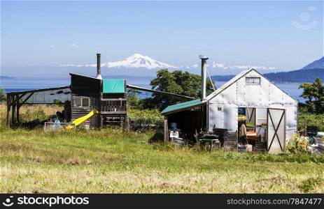 Two small outbuildings on a small organic farm on Waldron Island in Washington State. Mt. Baker is visible in the background.