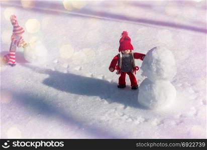 two small wooden dolls smiling faces in winter red clothes