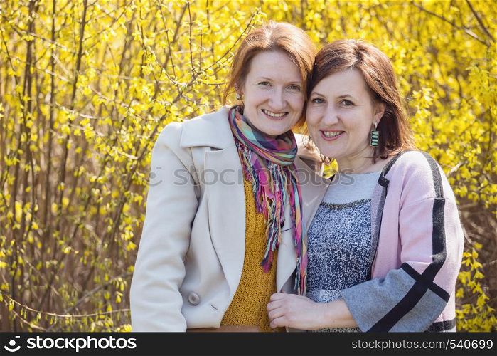 two smiling girlfriend portrait outdoors. bright spring