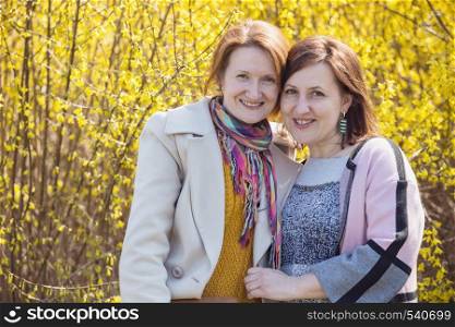 two smiling girlfriend portrait outdoors. bright spring