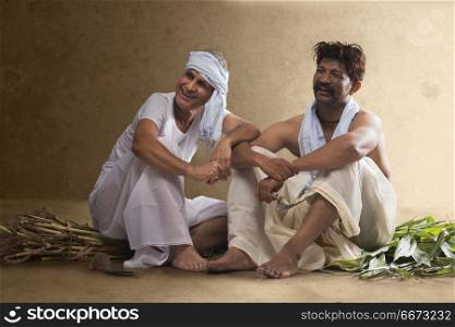 Two smiling Indian farmer sitting together