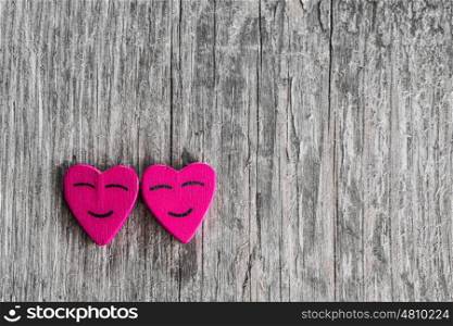 Two smiling pink hearts on wooden background, relationship valentines day concept