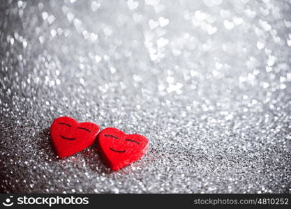 Two smiling red hearts on silver glitter background, relationship valentines day concept