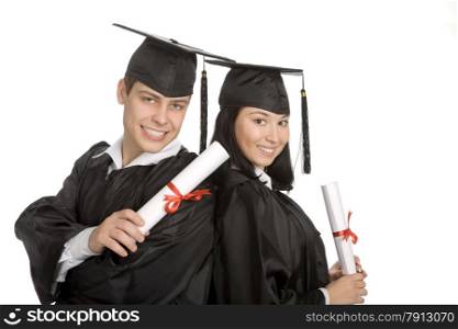 Two smiling students with diploma standing back to back at the white background