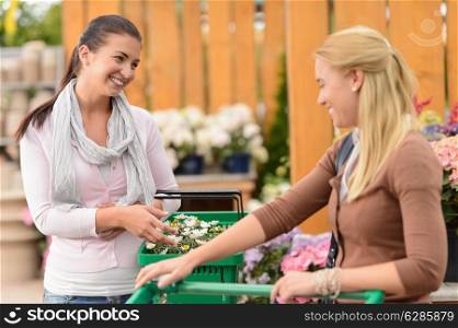 Two smiling woman shopping for plants in garden center