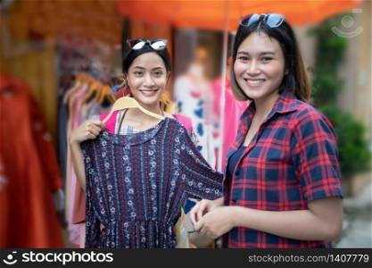Two smiling young woman Asian with shopping and buy at outdoor mall/supermarket/market