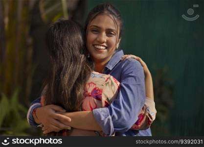 Two smiling young women embracing each other