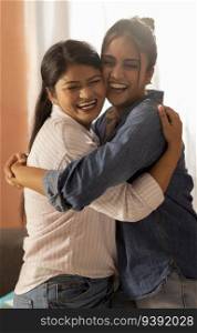 Two smiling young women hugging each other in living room