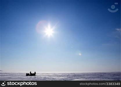 Two snowmobiles on a frozen lake in winter
