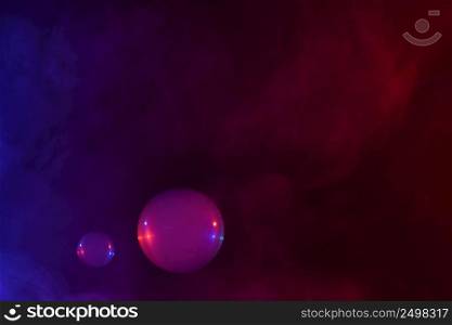Two soap bubbles filled with smoke flowing over abstract colorful clouds of vapor with copy-space.