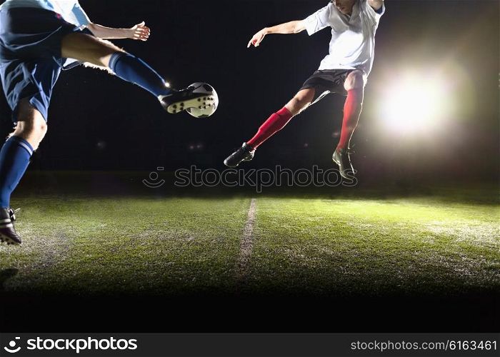 Two soccer players kicking a soccer ball