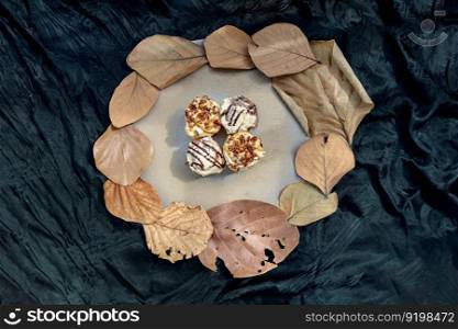 Two Soft Chocolate Buns topped with rich cream cheese frosting and Two Caramel Pecanbon topped with decadent caramel frosting and pecans on ceramic tray. The concept of delicious food, Top view, Space for text, Selective Focus.