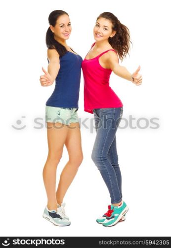 Two sporty young girls shows ok gesture isolated