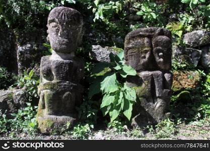 Two stone idols near grave in Ambarita village, Indonesia