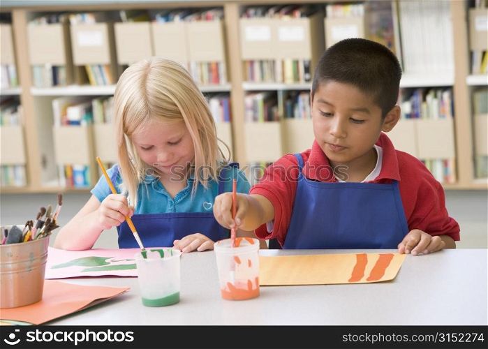 Two students in art class painting