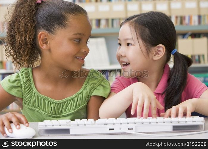 Two students in class at computer keyboard