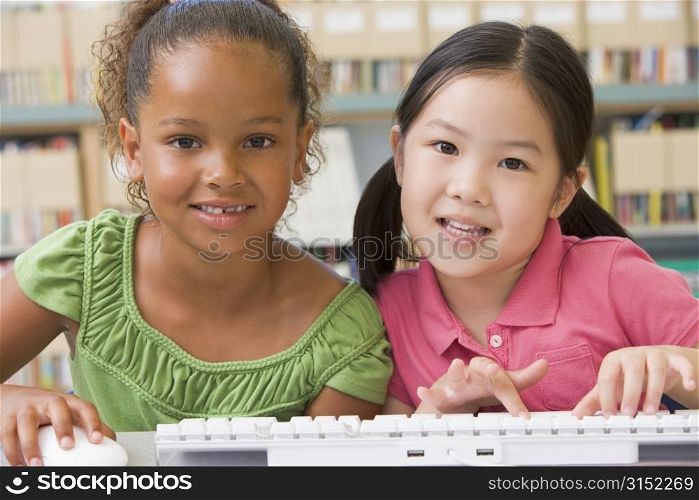 Two students in class at computer keyboard