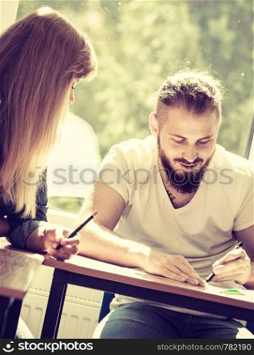 Two students sitting in class planning concept, studying together creating new startup enjoying their work time.. Two students in class