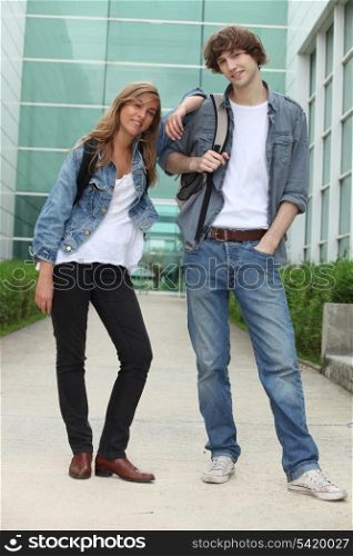 Two students standing outside a glass fronted building
