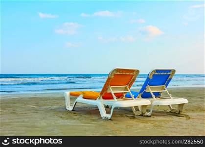 Two sun beds on a sandy beach