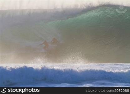 Two surfers on wave, Hawaii
