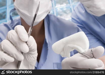 Two surgeons holding a scalpel and a surgical scissors