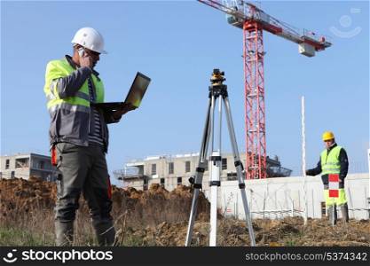 Two surveyors working on site
