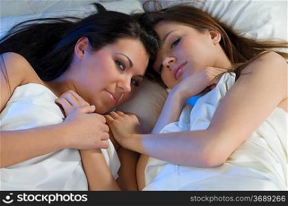 two sweet girls in bed face to face as close friends