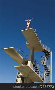 Two swimmers standing on diving board