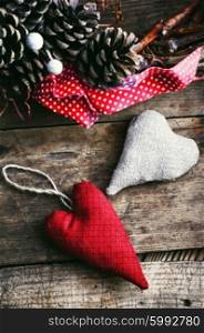 Two symbolic tissue of the heart has festive wreath with pine cones. Two symbolic hearts