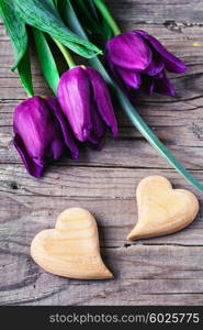 Two symbolic wooden heart on background of fresh flowers