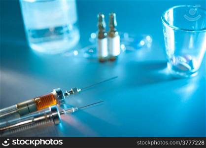 two syringe with dose. medication vials, pills closeup, selective focus.