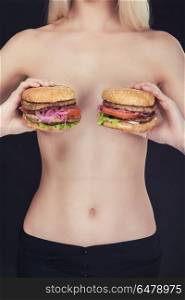 Two tasty burgers. Young naked woman keep in her hands two tasty burgers.