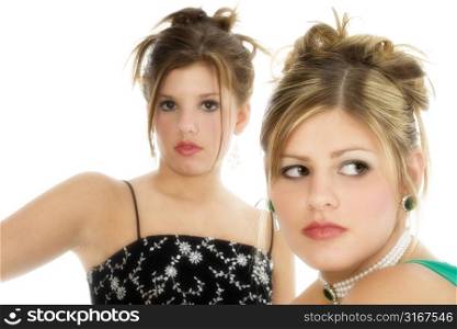 Two teen girls in formal dresses over white. Focus on teen in front.