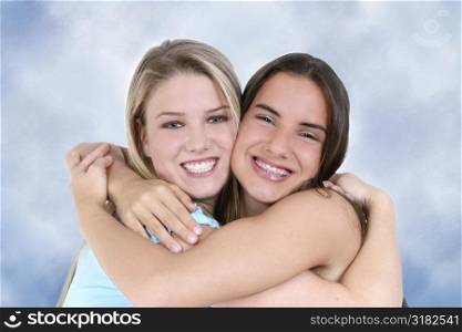 Two teen girls smiling and hugging.